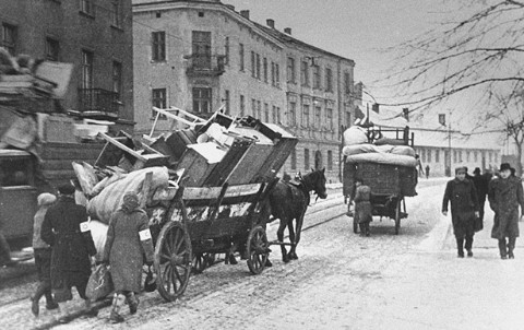 Jews move their belongings into the Krakow ghetto in horse-drawn wagons. 