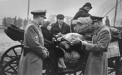 German soldiers check the papers of Jews moving into the Krakow ghetto. 