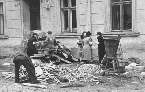 A group of Jews chop up furniture to use as fuel in the Krakow ghetto. 